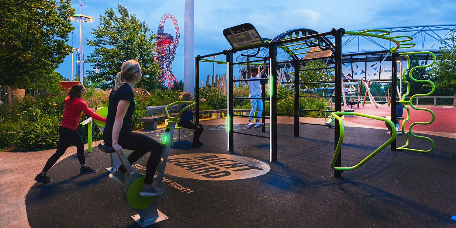 A young girl uses outdoor exercise equipment to exercise in a park